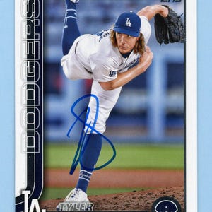 May include: A baseball card featuring a player in a Los Angeles Dodgers uniform. The player is in mid-pitch, wearing a blue cap with the team logo. The card has the Topps logo and the player's name, Tyler, is visible.