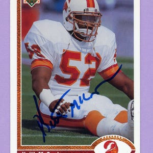 May include: A football trading card featuring Keith McCants in a white and orange Tampa Bay Buccaneers uniform. The card has a signature in blue ink and the number 52 is visible on the jersey. The Upper Deck logo is in the top left corner.