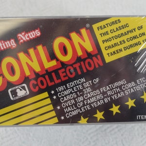 May include: A clear plastic case with a yellow and black card inside. The card features a red and yellow logo that says "The Sporting News Conlon Collection". The card also features the text "1991 Edition, Complete Set of Cards 1-330, Over 100 Cards Featuring Hall of Famers - Ruth, Cobb, etc., Complete Year by Year Statistics". The card has four gold stars and the text "Item # 9146".