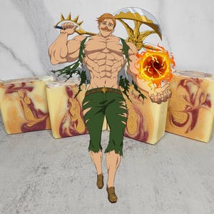 Puede incluir: Tres barras rectangulares de jabón artesanal con un diseño arremolinado de tonos rojos y dorados. Una ilustración de un personaje de anime musculoso sosteniendo un arma y una bola de fuego está en el fondo.