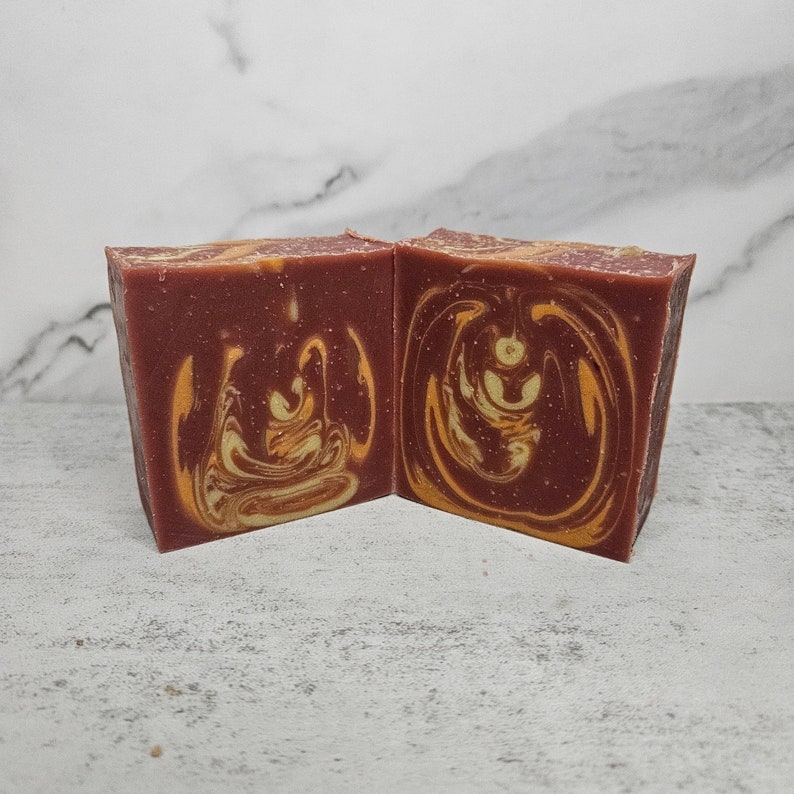May include: Two bars of handmade soap with a swirl pattern in shades of brown and yellow.