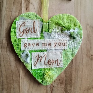 May include: Green fabric heart with the text "God gave me you Mom" in brown lettering.