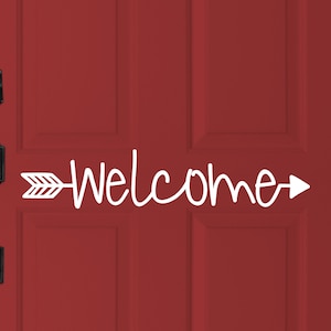 May include: A white vinyl decal with the word "Welcome" and an arrow pointing to the right, attached to a red front door.
