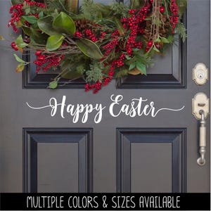 May include: A gray front door with a red and green holiday wreath. The door has a white vinyl decal that says "Happy Easter".