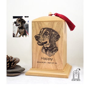 Puede incluir: Una urna de madera para mascotas con un borla roja. La urna tiene una imagen grabada con láser de un perro y el texto "Happy 2008.05.20 - 2021.07.12".