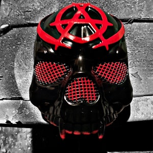 May include: Black skull mask with a red anarchy symbol on the top and red mesh over the eyes.