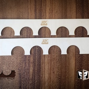 May include: Two wooden shelves with cutouts for holding paint bottles. The shelves are labeled "AK Interactive".
