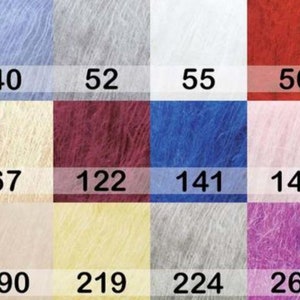 May include: A color chart of fluffy yarn samples in various shades, including pink, blue, white, red, and green. Each color is labeled with a number, such as 27, 40, 52, and 55. The yarn appears soft and textured.