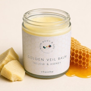 May include: A glass jar of Golden Veil Balm with a white label, tallow and honey. The jar is filled with a yellow balm. Beside the jar are two pieces of yellow wax and a piece of honeycomb with honey. The label reads "Mom Body & Sol Ancestry Co."