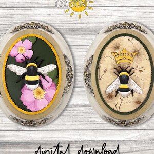 Può includere: Due targhe decorative ovali con disegni di api. Una presenta un'ape con fiori rosa, l'altra un'ape con una corona. Entrambe hanno bordi dorati e crema con accenti floreali. Il testo "digital download" è in basso.