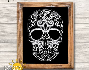 May include: A black and white sugar skull with intricate floral designs. The skull is framed in a brown wood frame.
