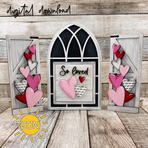 Op de afbeelding: Een houten decoratieset met Valentijnsthema. De set bevat een centraal boogvormig vensterontwerp met de woorden "So loved" en twee zijpanelen. Elk paneel en het venster zijn versierd met roze, rode en witte harten. De woorden "digital download" en het logo "CUTSUN" zijn ook zichtbaar.