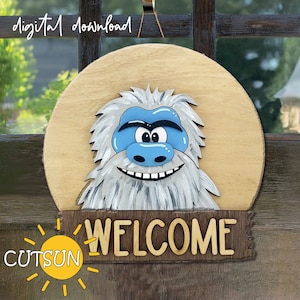 May include: A wooden welcome sign with a cartoon Yeti face and the word "WELCOME" in large letters. The sign is decorated with a yellow sun with rays and the text "CUTSUN".