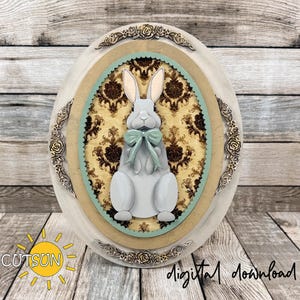 May include: A wooden Easter egg decoration featuring a grey bunny with a teal bow tie, set against a damask pattern. The design is framed with decorative floral elements and the text "digital download".