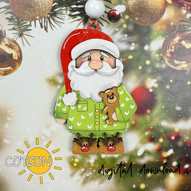 May include: Wooden Christmas ornament of Santa Claus in pajamas, holding a teddy bear. Santa wears a red hat, white beard, and green pajamas with white heart accents. His reindeer slippers and the text "digital download" are visible.