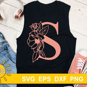 May include: A black tank top with a pink floral design and the letter "S" in the center. The text "SVG EPS DXF PNG" is printed at the bottom of the image.