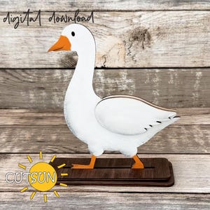 Könnte beinhalten: Holz-Gänsefigur mit weißem Körper, orangefarbenem Schnabel und Füßen sowie einem dunkelbraunen Sockel. Die Worte "digital download" stehen oben. Das Logo "CUTSUN" befindet sich unten.