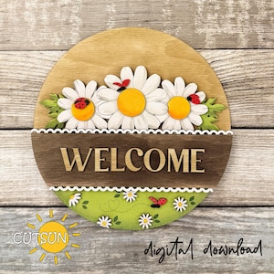 May include: A round wooden sign with a light brown background, featuring three white daisies with yellow centers and red ladybugs. The sign has a brown band with the word "WELCOME" and a green lower section with daisies and a ladybug.