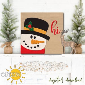 May include: A wooden sign with a snowman face and the word "hi" in red letters. The snowman is wearing a black top hat with a green holly sprig and red berries.