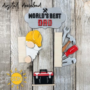 May include: A wooden craft project featuring a gnome with a yellow hard hat, a toolbox, and tools. The sign reads "World's Best Dad".
