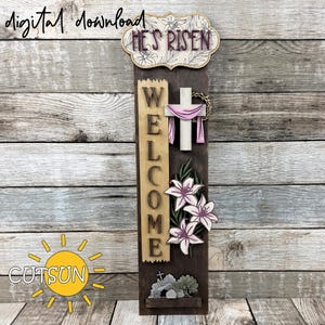 May include: Wooden Easter welcome sign with the text "HE'S RISEN" at the top. The sign features a cross with a pink drape, lilies, and the word "WELCOME". The sign is brown with a wooden background and the text "digital download" is at the top.