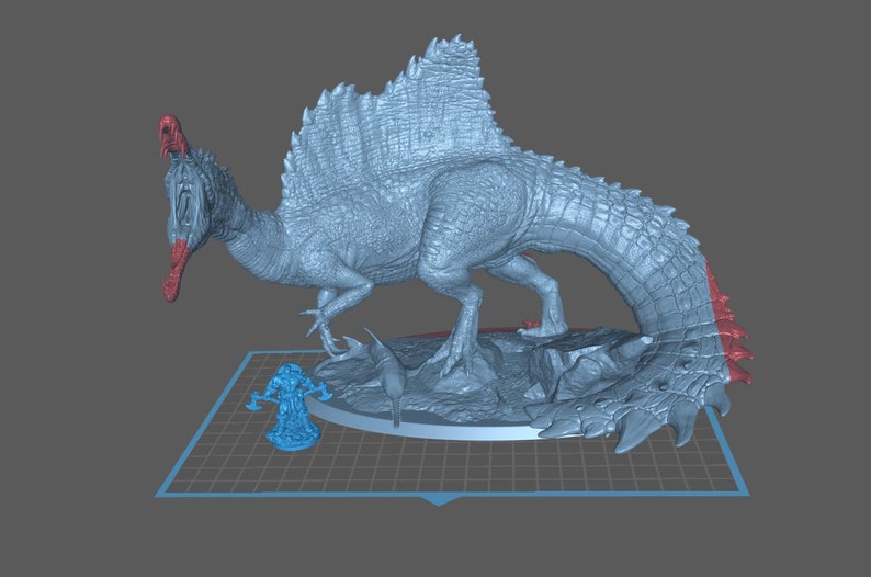 Puede incluir: Un modelo 3D impreso en gris de un dinosaurio Spinosaurus con un hocico largo y una gran vela en la espalda. El dinosaurio est&aacute; de pie sobre una base rocosa con una figura m&aacute;s peque&ntilde;a de un guerrero en primer plano.