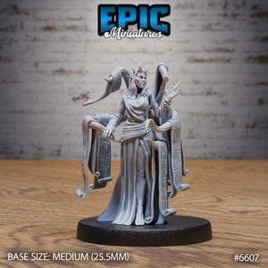 May include: A gray miniature figure of a female character with horns, a crown, and flowing robes. The figure is standing on a black base. The text "EPIC Miniatures" is at the top. The base size is medium (25.5mm).