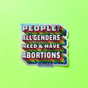 Pu&ograve; includere: Un adesivo arcobaleno con il testo "PEOPLE OF ALL GENDERS NEED & HAVE ABORTIONS" in lettere bianche. L'adesivo ha una finitura glitterata e il testo &egrave; in stile 3D. Il testo "@SARAH_EPPERSON" &egrave; in lettere bianche pi&ugrave; piccole nella parte inferiore dell'adesivo.