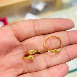 Puede incluir: Dos anillos de oro, uno con una banda redonda simple y el otro con un diseño de paisley.