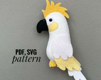 May include: A white and yellow felt cockatoo bird plush toy with a black beak. The toy is sitting on a gray background. PDF, SVG pattern.