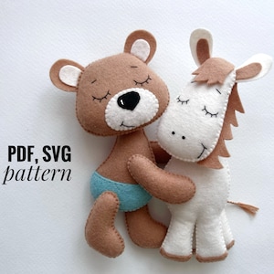 Puede incluir: Un oso de peluche marrón con pantalones cortos de fieltro azul y un caballo de fieltro blanco con crin y cola de fieltro marrón. Ambos animales de peluche tienen los ojos cerrados y se abrazan. El texto "PDF, SVG pattern" está escrito debajo de los animales.