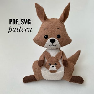 Puede incluir: Un canguro de fieltro marrón con un pequeño en su bolsa. El canguro está sentado sobre una superficie blanca. El texto "PDF, SVG pattern" es visible en la imagen.