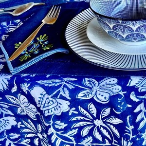 Peut inclure: Une table dress&eacute;e avec de la vaisselle &agrave; motifs bleus et blancs. La sc&egrave;ne comprend une nappe &agrave; motifs floraux, des assiettes, des bols et des couverts dor&eacute;s. L'esth&eacute;tique g&eacute;n&eacute;rale est un m&eacute;lange d'&eacute;l&eacute;gance et d'une touche de charme rustique.