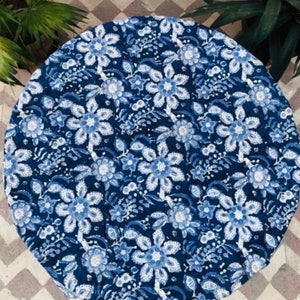 Peut inclure: Une nappe ronde avec un motif floral bleu et blanc. Le motif pr&eacute;sente de grandes fleurs stylis&eacute;es et de plus petits &eacute;l&eacute;ments floraux dans diff&eacute;rentes nuances de bleu sur un fond bleu fonc&eacute;. La nappe est en tissu doux.
