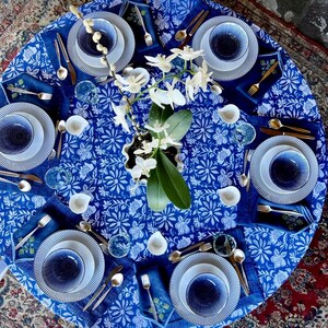 Peut inclure: Une table joliment dress&eacute;e avec de la vaisselle &agrave; motifs bleus et blancs, comprenant des assiettes, des bols et des serviettes. Des couverts dor&eacute;s et des verres transparents compl&egrave;tent l'ensemble. Un centre de table d'orchid&eacute;es blanches ajoute une touche d'&eacute;l&eacute;gance.