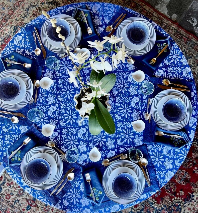 Peut inclure: Une table joliment dress&eacute;e avec de la vaisselle &agrave; motifs bleus et blancs, comprenant des assiettes, des bols et des serviettes. Des couverts dor&eacute;s et des verres transparents compl&egrave;tent l'ensemble. Un centre de table d'orchid&eacute;es blanches ajoute une touche d'&eacute;l&eacute;gance.
