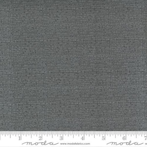 May include: A close-up of a dark gray fabric with a subtle woven texture. The fabric has a slightly textured surface and a subtle sheen.