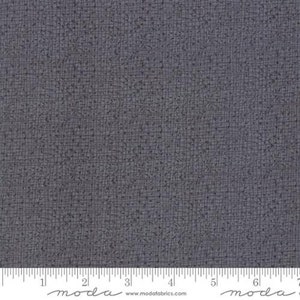 May include: A close-up of a dark grey fabric with a subtle textured pattern. The fabric has a slightly speckled appearance, with tiny dots scattered throughout. The fabric is smooth and soft to the touch.