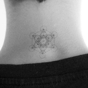 May include: A black and white geometric tattoo design of a sacred geometry symbol on a person's neck.