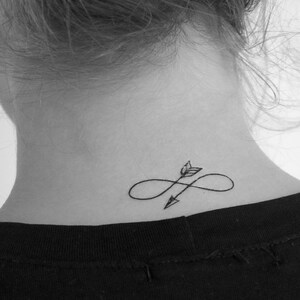 May include: A black and white tattoo of an arrow piercing through an infinity symbol on a person's neck.