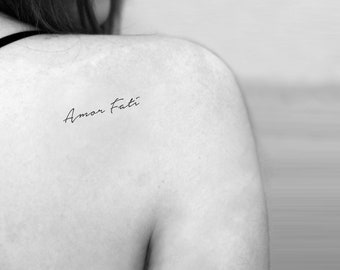 Amor Fati lettering tattoo on the inner forearm