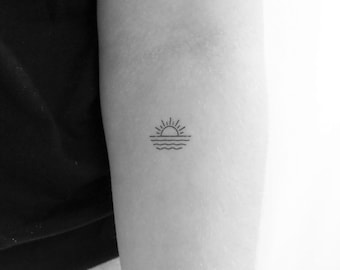 Puede incluir: Un tatuaje sencillo de línea de un sol poniéndose sobre el océano.