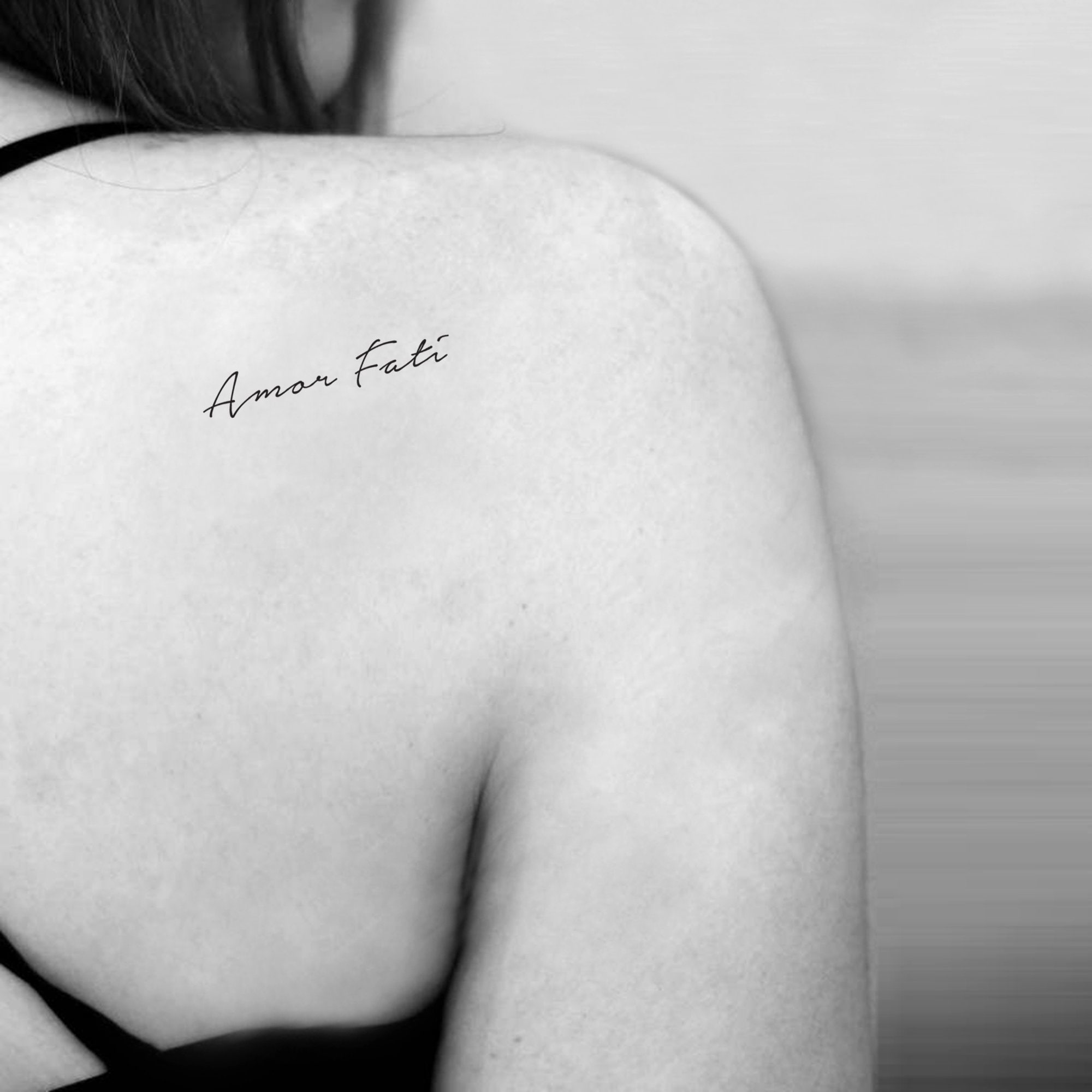 Amor fati and arrow tattooed on the wrist