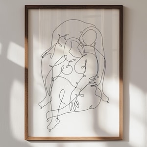 May include: A framed art print featuring a minimalist line drawing of two figures embracing. The artwork is rendered in black lines on a white background, encased in a brown wooden frame. The piece evokes themes of connection and intimacy.