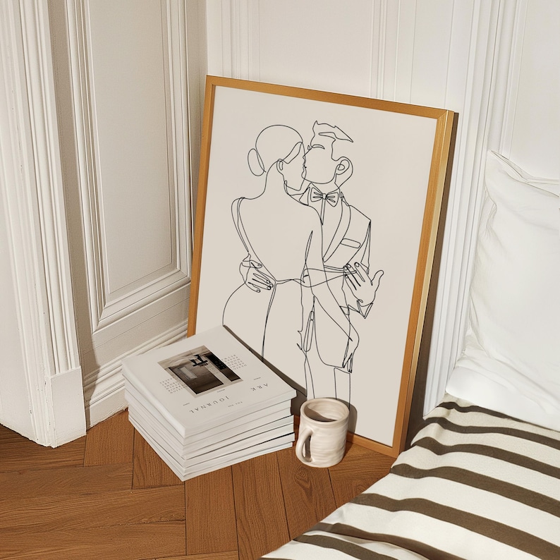 K&ouml;nnte beinhalten: Eine Schwarzwei&szlig;-Linienzeichnung eines sich k&uuml;ssenden Paares. Die Zeichnung ist in einem goldenen Rahmen gerahmt und h&auml;ngt an einer wei&szlig;en Wand. Das Paar ist in festlicher Kleidung gekleidet.