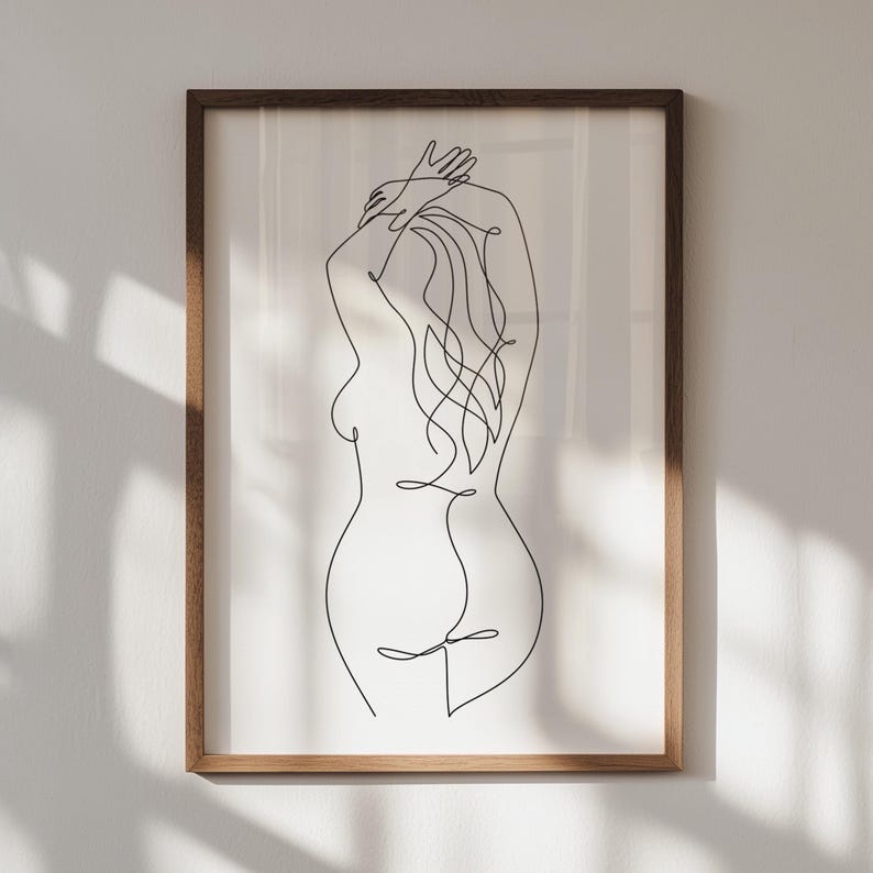 Puede incluir: Una impresi&oacute;n enmarcada de arte lineal minimalista. La obra de arte representa la silueta de la espalda de una persona, con los brazos levantados y el pelo largo. La impresi&oacute;n est&aacute; en un marco de madera, creando una est&eacute;tica simple pero elegante.