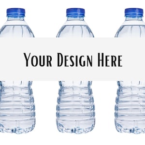 May include: Three clear plastic water bottles with blue screw-on caps arranged in a row. A horizontal white rectangular banner is placed across the center of the bottles, featuring the black text "YOUR DESIGN HERE" in a clean, sans-serif font.
