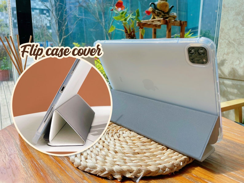 May include: A light blue tablet case with a clear back and a flip cover. The case is folded to create a stand for the tablet. The text "Flip case cover" is visible in the image.