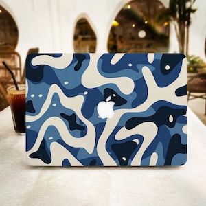 Könnte beinhalten: Ein Laptop mit einem blauen und weißen abstrakten Muster auf der Abdeckung. Das Muster besteht aus wirbelnden Formen und Linien.