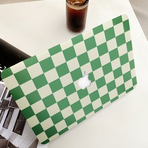 Puede incluir: Piel de port&aacute;til a cuadros verdes y blancos con un logotipo de Apple.